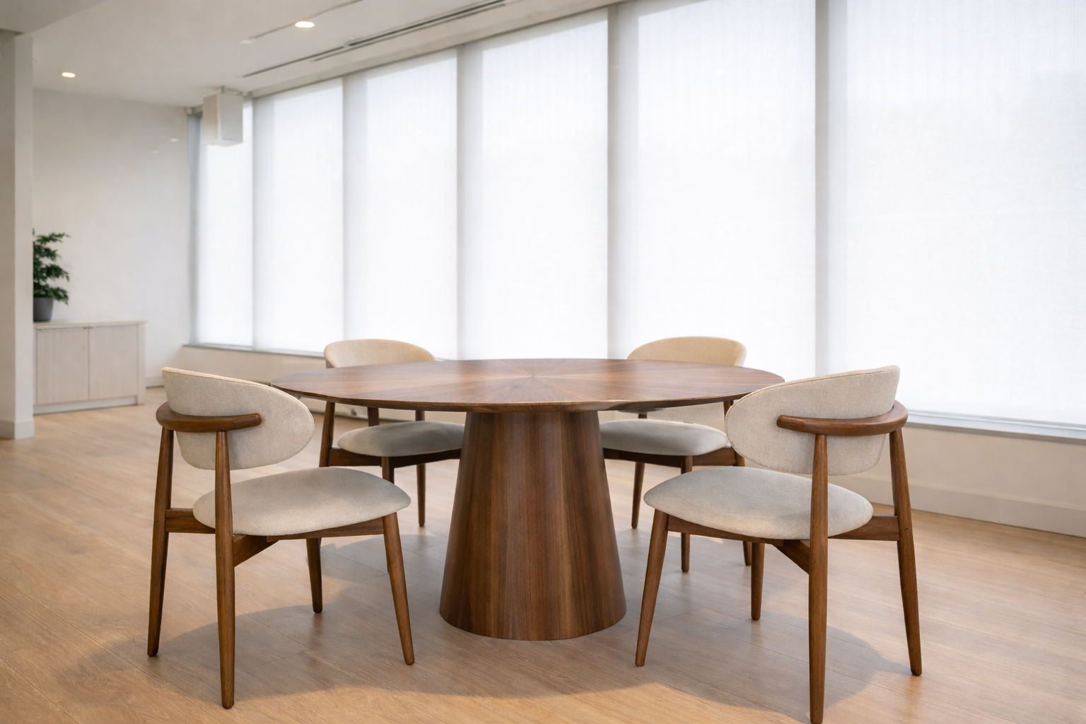 Table ronde en noyer massif design avec pied central dans un espace intérieur lumineux et épuré avec chaises en tissu beige